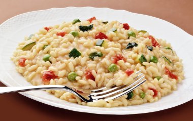 Çanak çatal ile risotto kabak bezelye domates