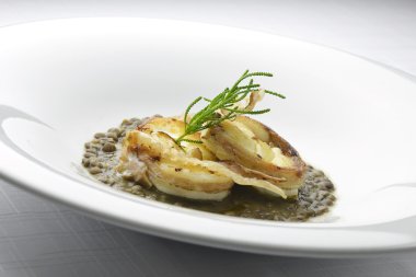 Maymunbalığı mercimek üzerinde gevrek domuz pastırması ile