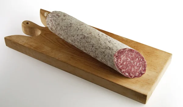 Salami knippen op snijplank — Stockfoto