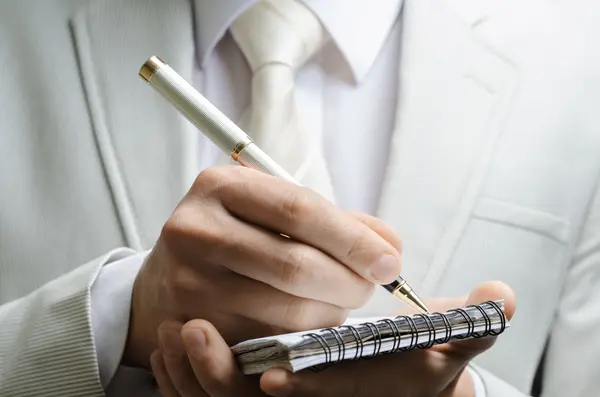 Man in a suit with a notebook — Stock Photo, Image