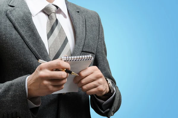 Homme d'affaires en costume avec un cahier et un stylo dans les mains — Photo