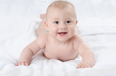 mutlu bebek beyaz bir halı üzerinde yalan