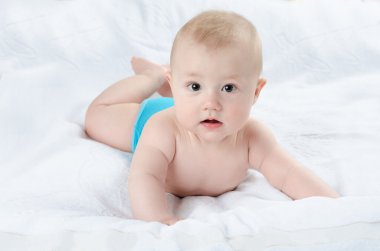 mutlu bebek beyaz bir halı üzerinde yalan