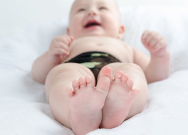 mutlu bebek beyaz bir halı üzerinde yalan