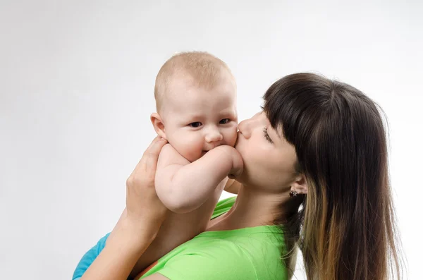 Madre joven besando a sus hijos pequeños — Foto de Stock