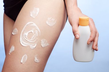 genç bir kadının bacak güneş kremi