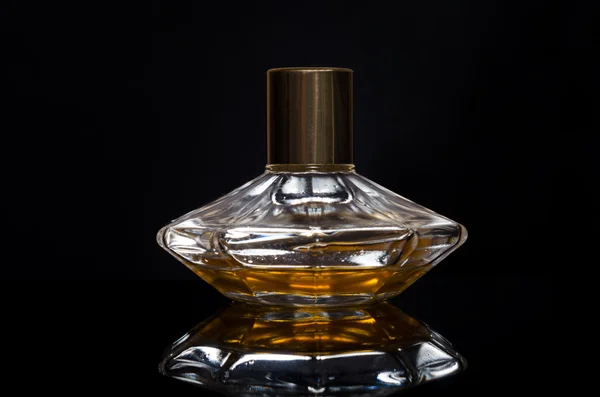 Garrafa de perfume feminino em um fundo preto — Fotografia de Stock