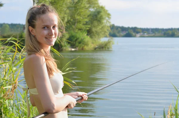 Genç kadın gölde balık tutma — Stok fotoğraf