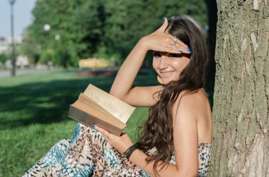 genç esmer parkta bir kitap okuma