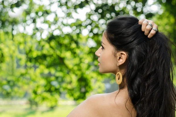 Doğa arka plan üzerinde genç bir esmer portresi