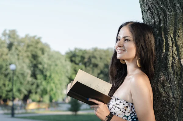 genç esmer parkta bir kitap okuma