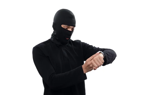 Dief in het masker ziet er op de klok — Stockfoto