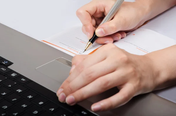 Female hand write information from a laptop notebook — Stock Photo, Image