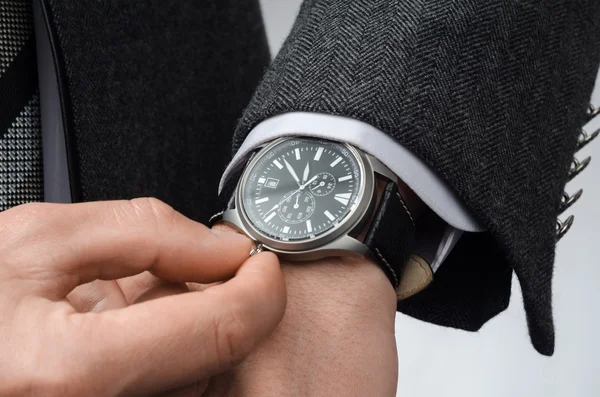 Businessman adjusts the time on his wristwatch — Stock Photo, Image