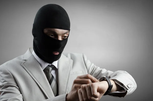 Robber in a white tuxedo looks at the clock Stock Image
