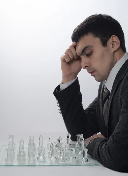 Businessman playing chess on a light background — Stock Photo, Image