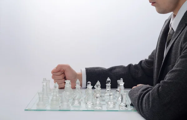 Hombre de negocios jugando ajedrez sobre un fondo claro — Foto de Stock