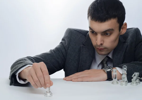 Hombre de negocios jugando ajedrez sobre un fondo claro — Foto de Stock