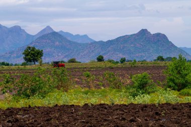 Boş tarım arazisi, sürülmüş tarlalar, verimli, siyah ve kahverengi toprak ekime hazır. Tohum ekmek ve ekmek için tarla hazır. Dağlarla çevrili tarlalar ve ağaçlar.