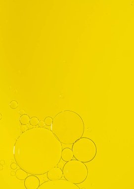 Sarı besin rengiyle karıştırılmış sarı renkli su üzerindeki bir balonun soyut Makro Fotoğrafı. Boş alanı olan makro balon fotoğrafçılığı