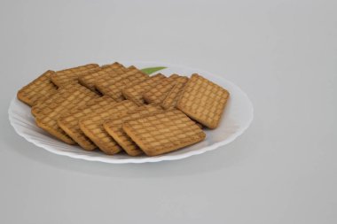 Beyaz bir tabakta Hint çay bisküvileri yakın çekim ve izole edilmiş beyaz arka plan ve kopyalama alanı. Hindistan 'da Chai-bisküvi olarak bilinen Hint çay bisküvileri.