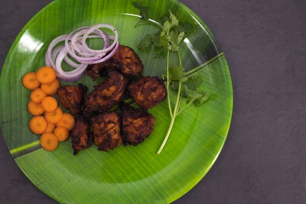 Famous South Indian non veg appetizer snack- chicken 65. Top view of Indian non veg food. Side dish for rice, Chapati, Paratha. coconut oil Deep fried chilli chicken south indian style.