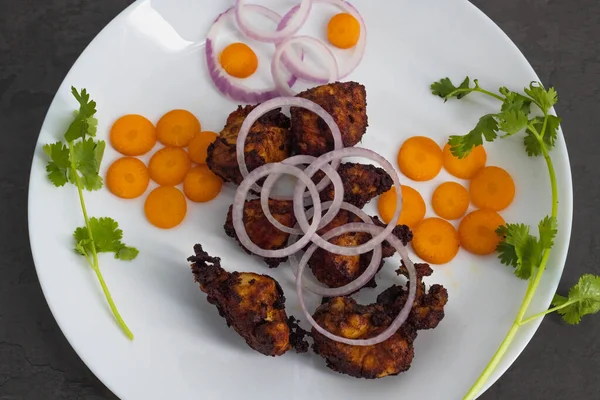 Famous South Indian non veg appetizer snack- chicken 65. Top view of Indian non veg food. Side dish for rice, Chapati, Paratha. coconut oil Deep fried chilli chicken south indian style