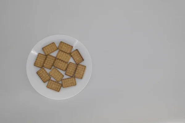 Close up shot of Indian tea biscuits on a white plate and isolated with white background and copy space. Indian tea biscuits popularly known as Chai-biscuit in India