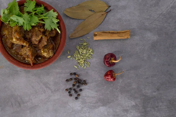 Indian cuisine, Spicy and delicious mutton curry in traditional clay pot. Tasty mutton roast with Indian spices .Mutton masala -Selective focus photograph