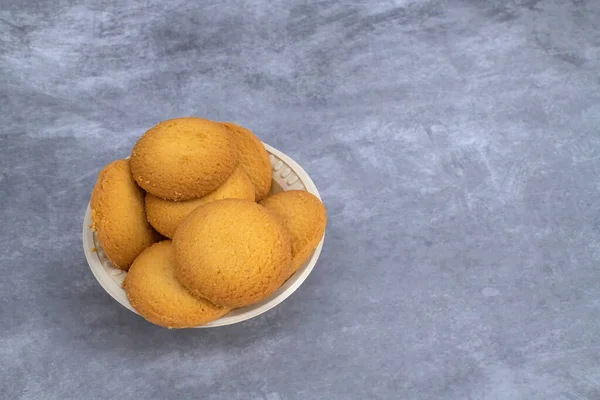 Indian tea biscuits on a white cup and isolated with gray background and copy space. Indian tea biscuits popularly known as Chai-biscuit in Indi