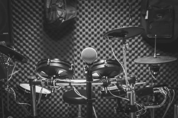 De microfoon en de musical instrument de gitaar, drum, sprekers achtergrond. — Stockfoto