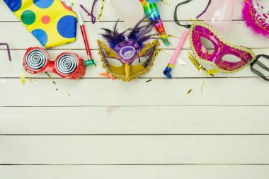 Masa üstü görüntü güzel renkli karnaval festivali arka planı. Düz nesne, ofis odasındaki modern beyaz ahşap konfeti üzerine birkaç maske dekor konfetisi yatıyordu. Kopya alanı.