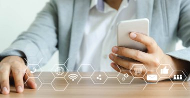 İşadamı ofis masasındaki dijital çevrimiçi pazarlama için cep telefonunu kullanarak mor gömlek giyer. İş finans teknolojisi kavramı. İnternet üzerinden e-ticaret küresel pazar alışverişi, bankacılık ve ödemeler.