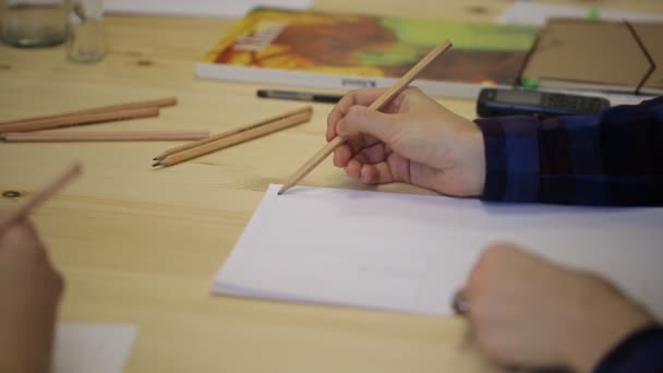 Zenske ruku s tužkou nakreslí na list papíru v řadě.