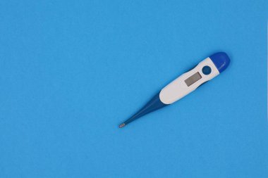 Fever thermometer isolated on a blue background. Concept of fever and illness.