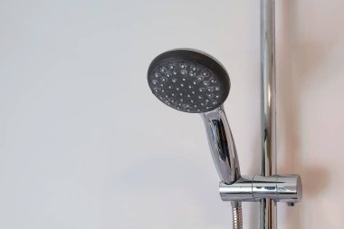Kireç pullu duş başlığı ayarlanabilir bir tutacağa banyoda duvara dayalı..