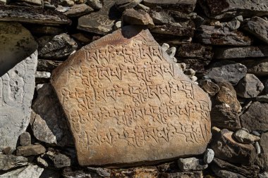 Nepal karakterlerle oyulmuş taşlar
