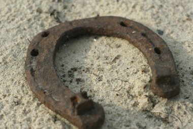 Paslı nal kum arka plan - bir ülke tarzı rustik sahne üzerinde. Eski demir at nalı - iyi şanslar sembolü ve refah içinde bir köy evinin Batı kültüründe maskotu.