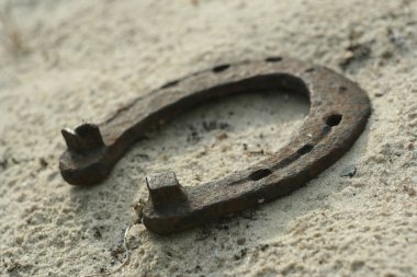 Paslı nal kum arka plan - bir ülke tarzı rustik sahne üzerinde. Eski demir at nalı - iyi şanslar sembolü ve refah içinde bir köy evinin Batı kültüründe maskotu.