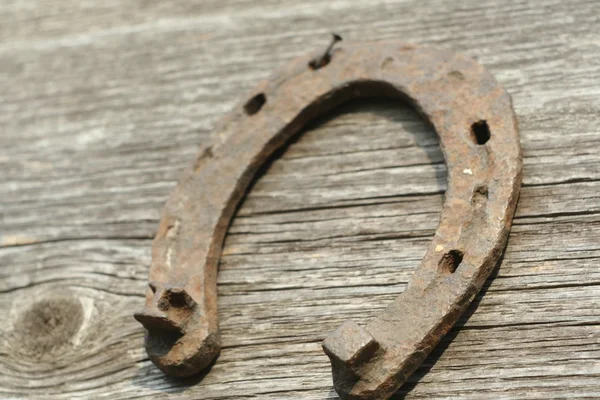 Paslı nal ahşap arka plan - bir ülke tarzı rustik sahne üzerinde. Eski Demir at nalı - iyi şanslar sembolü ve refah içinde bir köy evinin Batı kültüründe maskotu.