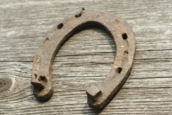 Paslı nal ahşap arka plan - bir ülke tarzı rustik sahne üzerinde. Eski Demir at nalı - iyi şanslar sembolü ve refah içinde bir köy evinin Batı kültüründe maskotu.