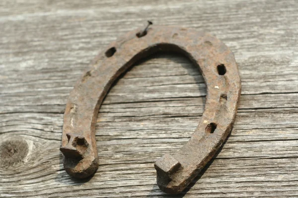 Paslı nal ahşap arka plan - bir ülke tarzı rustik sahne üzerinde. Eski Demir at nalı - iyi şanslar sembolü ve refah içinde bir köy evinin Batı kültüründe maskotu.