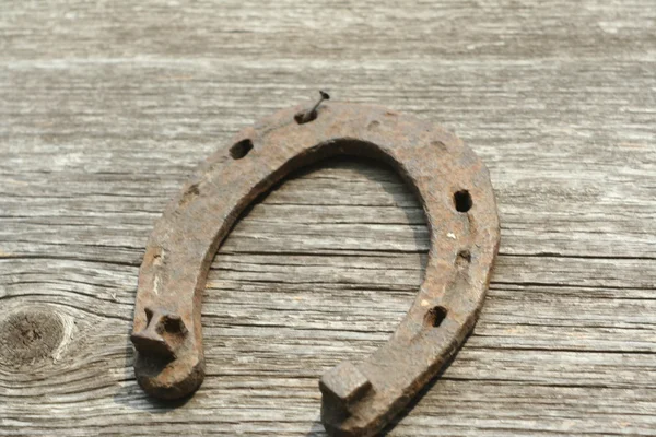 Paslı nal ahşap arka plan - bir ülke tarzı rustik sahne üzerinde. Eski Demir at nalı - iyi şanslar sembolü ve refah içinde bir köy evinin Batı kültüründe maskotu.