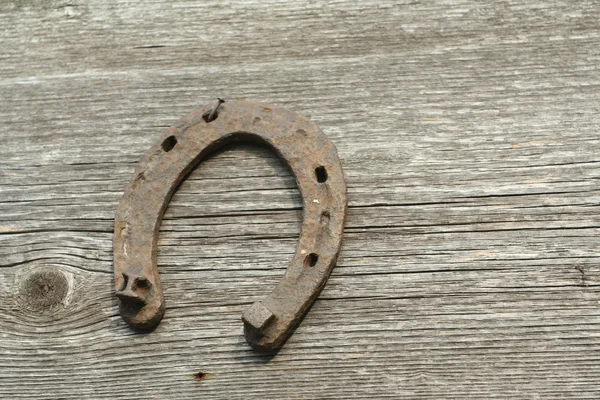 Paslı nal ahşap arka plan - bir ülke tarzı rustik sahne üzerinde. Eski Demir at nalı - iyi şanslar sembolü ve refah içinde bir köy evinin Batı kültüründe maskotu.