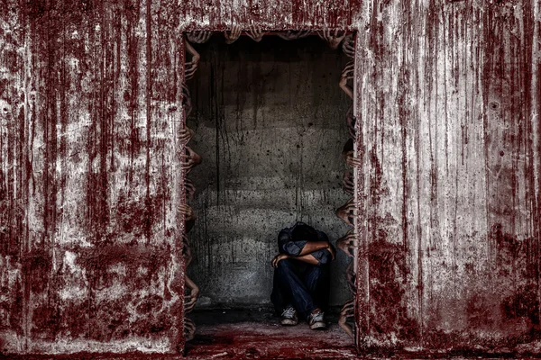 Algunas personas sentadas en el aterrador edificio abandonado con la pared de sangre — Foto de Stock