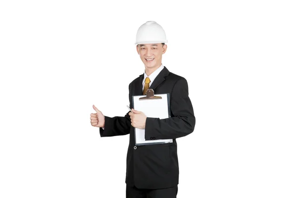 Happy asian young man in suit with helmet and clipboard gesturing thumbs up, isolated on white — Stock Photo, Image