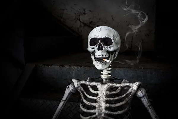 Натюрморт Курение человеческий скелет с сигаретой, люди курят сигарету, как будто пытаются покончить жизнь самоубийством, в день "Всемирный день без табака", пожалуйста, бросить курить или бросить курить для хорошего здоровья . — стоковое фото