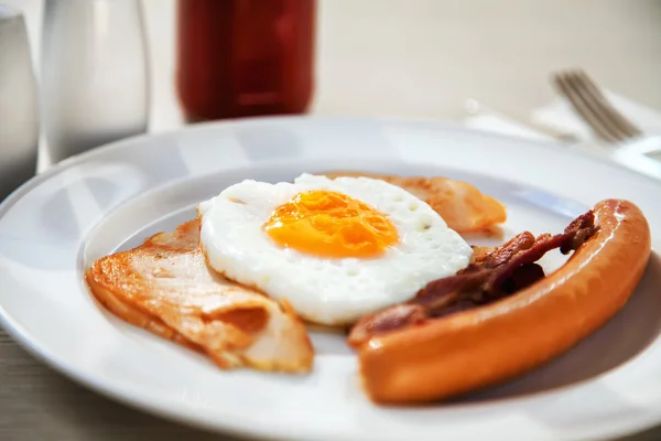 Café da manhã ovos, presunto, salsicha e bacon sob luz da manhã (foco seletivo ) — Fotografia de Stock