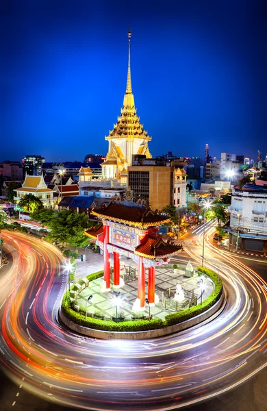 stock image The gateway arch (Odeon Circle) and Traimit temple behind with light trails from long exposure photo taken, Landmark of Chinatown Bangkok Thailand. (Chinese character is meant 