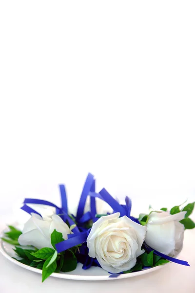 Roses blanches attachées avec un ruban violet sur une assiette . — Photo